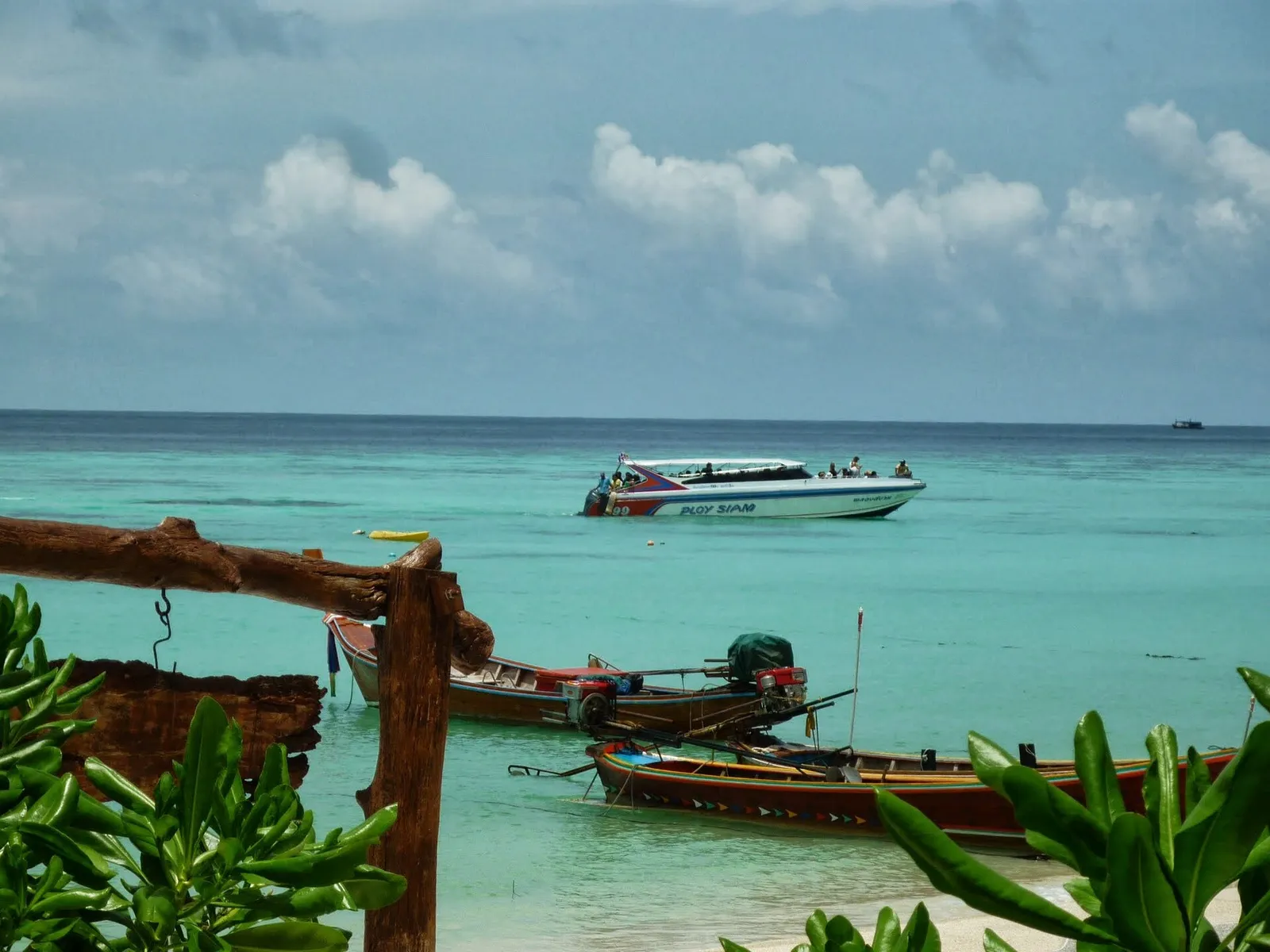 Longtail boats and a speedboat moored off a Koh Lipe beach